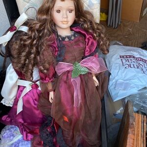 Pretty porcelain  doll in  a burgundy dress